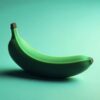 A single ripe banana on a teal background.